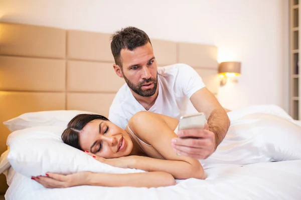 Jealous Husband Spying Phone His Partner While She Sleeping Bed - Stock-foto