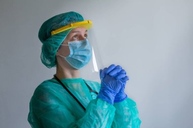 PPE üniformalı doktor, Coronavirus salgını veya Covid-19, Covid-19 karantinasında stres altında ve dua ediyor..