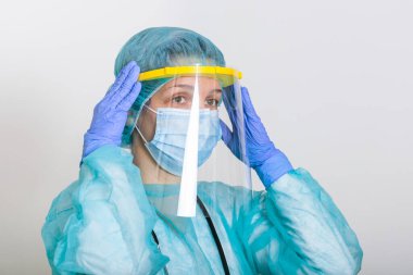 Coronavirus salgını veya Covid-19, Covid-19 karantinası için PPE kıyafeti giymeyi öğreten doktor. Corona virüsü ile savaşmak için koruyucu giysi giyen doktor hemşire (Corona virüsü)