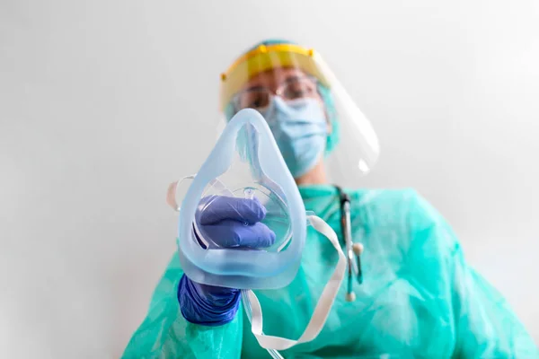Doctor Woman holds Oxygen Mask for Inhale breath problem Patient, Coronavirus or Covid-19 attack Lungs. Healthcare worker in protective equipment put on oxygen mask patient diagnosis of coronavirus