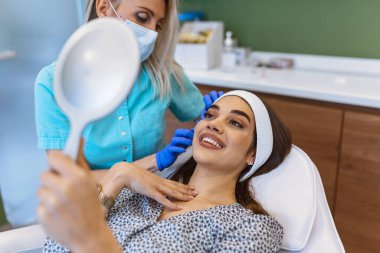 Gevşeme ve vücut bakım kavramı. Kadın terapist spa salonda genç kadın alın kırışıklıkları Anti-yaş masaj yapmasını portresi en iyi açı