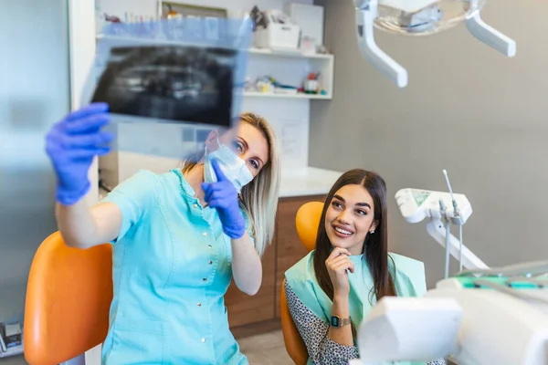 Jaw scan is being explained by the dentist to the patient. . Wearing protective masks respecting the prescribed safety measures regarding the Covid-19 pandemic.