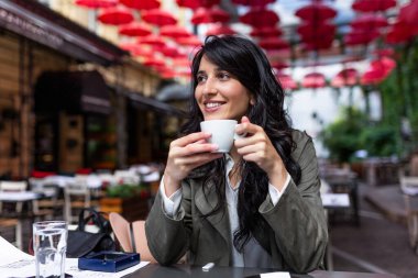 Bir fincan kahveyle güzel bir genç bayan. Sabahları kahve dükkanında gün doğumuyla birlikte sabahları kahve içen güzel bir kadın.