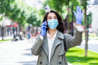 Yüz koruyucu maskeli bir kadın. Coronavirus ve anti-sisi önlemek için yüz koruyucu maske takan genç bir kadının portresi. Yüz maskesi takan genç bir kadının portresi