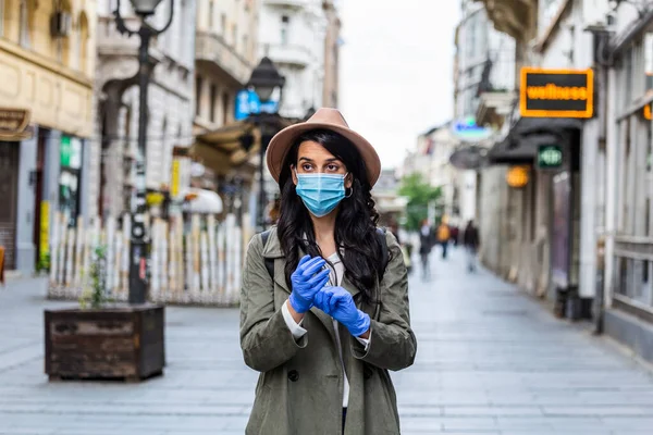 Girl in respiratory mask. Cold, flu, virus, tonsillitis, respiratory disease, quarantine, epidemic concept. Young woman on the street wearing face protective mask to prevent Coronavirus and anti-smog
