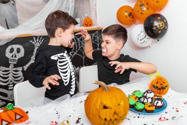 Mutlu Cadılar Bayramı! Ağabeyi ile çekici bir genç çocuk Cadılar Bayramı partisine hazırlanıyor. Kostümlü kardeşler eğleniyor ve birbirlerini korkutuyorlar.