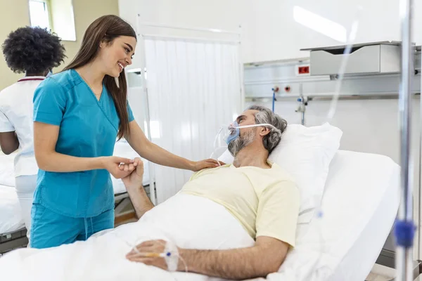 Healthcare concept of professional doctor consulting and comforting elderly patient in hospital bed or counsel diagnosis health. Medical doctor or nurse holding senior patient's hands and comforting him