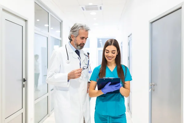 Side View Portrait Two Medics Writing Clipboard While Standing Medical — Stockfoto