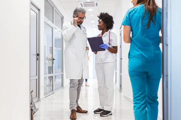 Group Medics Clipboard Discussing Hospital Corridor Doctor Nurse Briefing Medical — Stockfoto