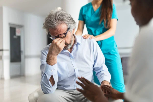Doctor consoling upset man in hospital waiting room. Patient receiving bad news, he is desperate and crying, Doctor support and comforting her patient with sympathy. Don\'t worry, this medical test is not so bad