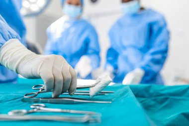 Hemşire el grup hastada cerrahi tiyatro çalışma arka plan, cerrah cerrahi alet götürmek. Çelik tıp aletleri kullanılmak üzere hazır. Cerrahi ve acil kavramı