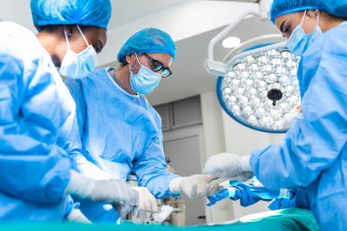 Cerrahlar ameliyathanede ameliyat yapıyorlar. Ameliyathane cerrahi aletlerinde göğüs büyütme ameliyatı. Tıbbi bakım konsepti.