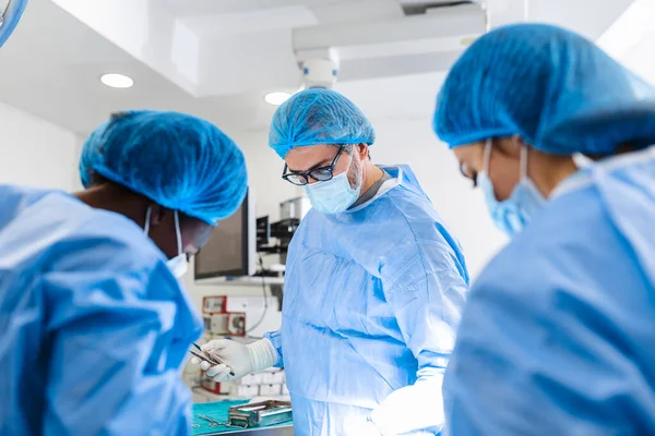 A surgeon's team in uniform performs an operation on a patient at a cardiac surgery clinic. Modern medicine, a professional team of surgeons, health.