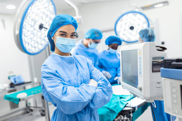 Anesthesiologist keeping track of vital functions of the body during cardiac surgery. Surgeon looking at camera. Doctor checking monitor for patient health status.