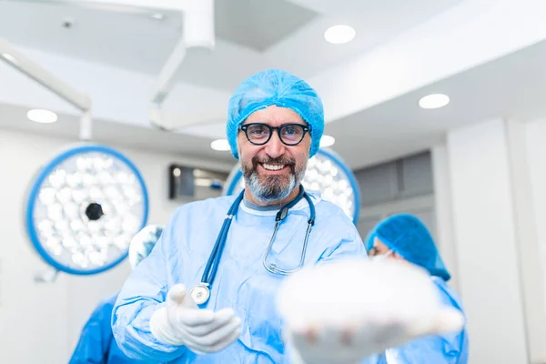 Egy Sebész Orvos Mosolyog Szilikon Mellimplantátumot Tart Kezében Mellimplantátum Sebész — Stock Fotó