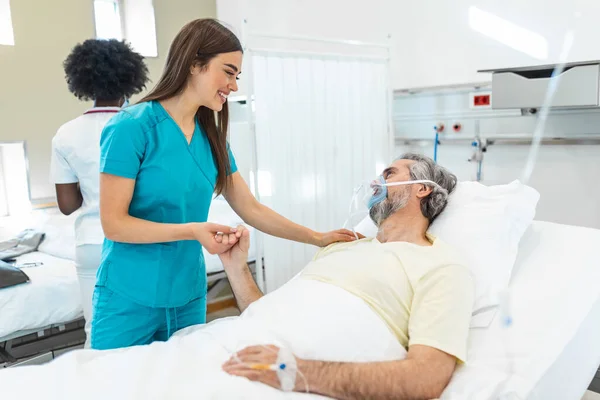 Healthcare concept of professional doctor consulting and comforting elderly patient in hospital bed or counsel diagnosis health. Medical doctor or nurse holding senior patient\'s hands and comforting him