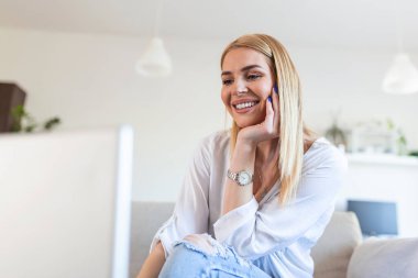 Güzel kadın serbest yazar dizüstü bilgisayarla uzaktan kumandayı planlama projesi için bilgi topluyor. Modern dizüstü bilgisayarda e-posta okurken gülen kız .