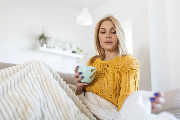 Sick Woman Covered With a Blanket Lying in Bed With High Fever and a Flu, Resting at Living Room. She Is Exhausted and Suffering From coronavirus. Sick Woman With Runny Nose Lying in Bed.