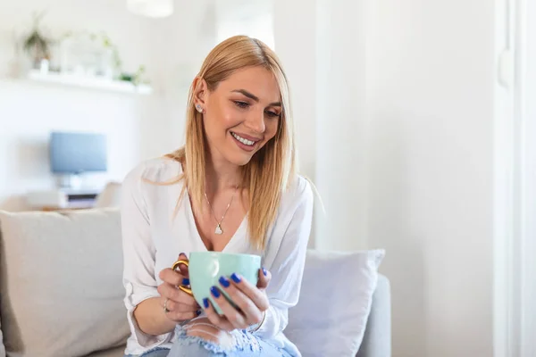 Closeup view of young woman with cup of hot drink at home, blank space. People, drinks and leisure concept - happy young woman with cup of tea or coffee at home