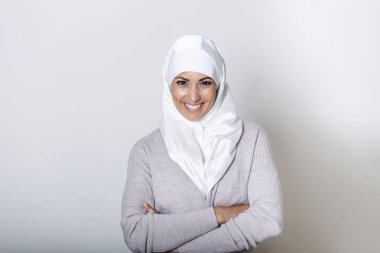 Portrait of pretty young arab muslim woman in head scarf smile. Portrait closeup of muslim woman 20s in hijab smiling isolated over white background.