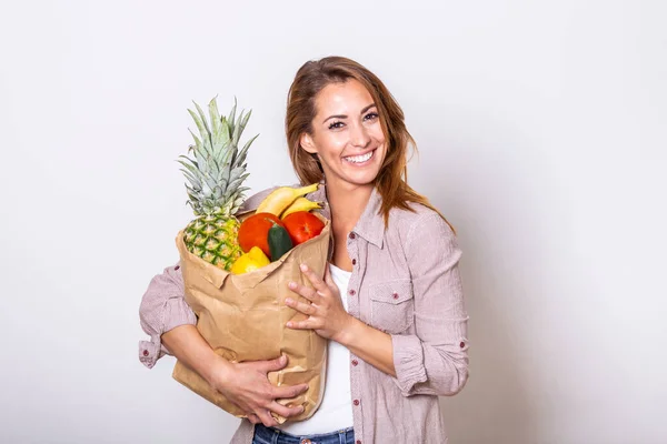 Portrait of beautiful young woman grocery shopping bag with vegetables at home. Young woman holding grocery shopping bag with vegetables