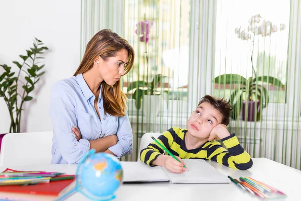 Child having problem with concentration while doing homework. Stressed Mother and Son Frustrated Over Failure Homework, School Problems Concept. Mother help her is son make difficul homework