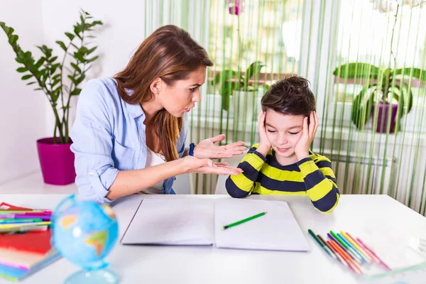 Stressed mother and son frustrated over failure homework, school problems concept. Sad little boy turned away from mother, does not want to do boring homework