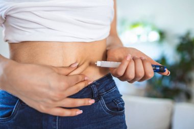 Evde insülin iğnesi yapmak için insülin kullanan diyabetik bir hasta. Diyabeti kontrol eden genç bir kadın. Şeker hastası yaşam tarzı