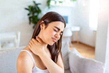 Yorgun bir kadın, ağrıyan boynuna masaj yapıyor, bilgisayarın çalışmasından yorgun düşmüş kaslar, omuz eklem ağrısı hissederken yanlış bir duruş sergiliyor. Fibromiyalji kavramı