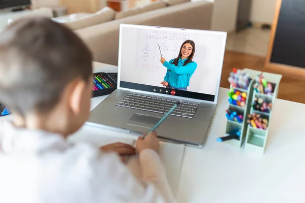 Online remote learning. School kids with computer having video conference chat with teacher and class group. Child studying from home. Homeschooling during quarantine and coronavirus outbreak.