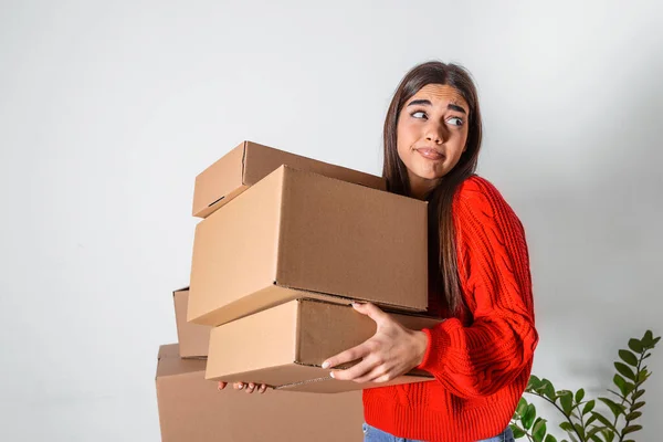 Young woman just moved in into new empty apartment unpacking and cleaning - relocation. Young girl carrying cardboard boxes at new home.Moving house.