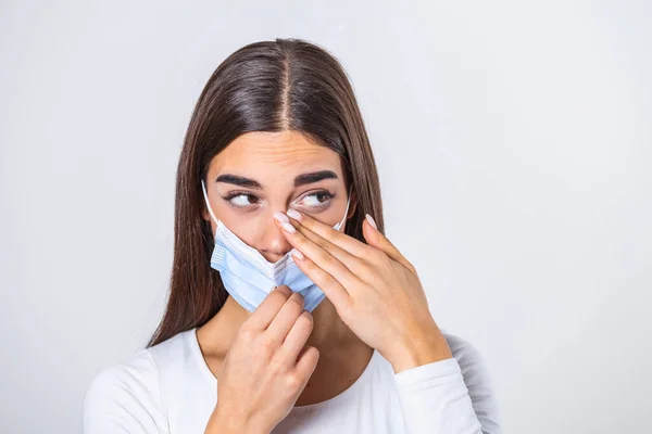 Don't Touch Your Face. Girl wearing surgical mask rubbing her eye with dirty hands.Precautions, Avoid Touching Your Eyes. Woman in medical mask rubbing her eye