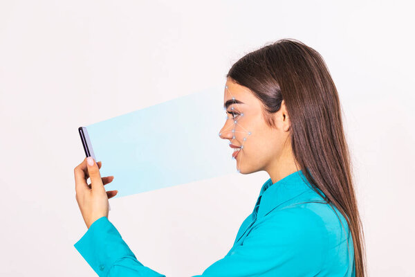 Biometric identification. Young beautiful woman scanning face with facial recognition system on smartphone.