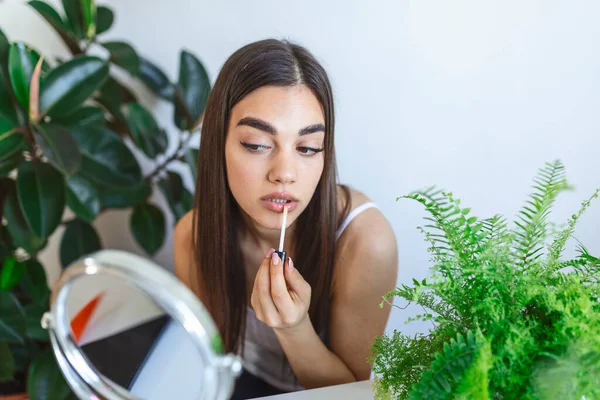 Beautiful Young Woman Applying Lip Gloss Applicator Front Mirror Home — ストック写真