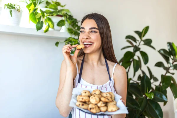 Young Beautiful Housewife Holding Freshly Baked Cookies Tray Kitchen — Stockfoto