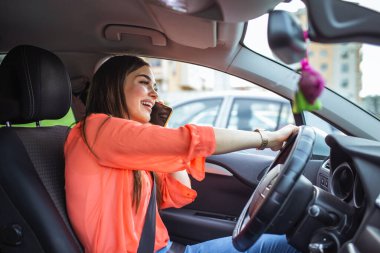 Businesswoman driving car and talking on cell phone concentrating on the road. Driving while holding a mobile phone cell phone use while driving. Woman In Car Talking On Mobile Phone Whilst Driving