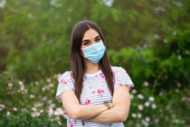Solunum maskeli kız. Maskeli kadın kameraya bakıyor. Soğuk algınlığı, grip, virüs, bademcik iltihabı, solunum hastalığı, karantina, salgın hastalık konsepti. Tek kullanımlık maskesiyle güzel bir beyaz kadın.