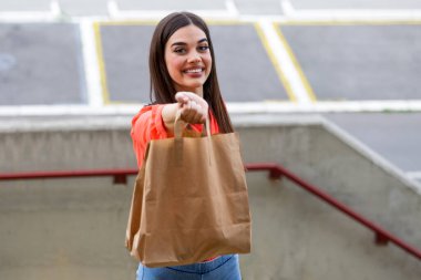 Express grocery delivery service. Smiling young woman looking at camera holding eco bag deliver grocery food delivery social donation