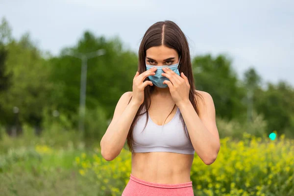 Runner wearing medical mask, Coronavirus pandemic Covid-19. Active life in quarantine surgical sterilizing face mask protection. Outdoor run in Corona Outbreak. Keep your shape during quarantine