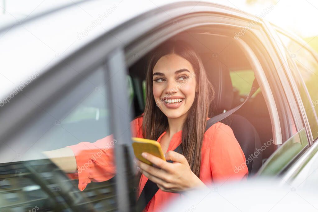 Woman driver using a smart phone in car. Woman driver using a smart phone in car. Leisure, road trip, technology, travel and people concept - Happy woman driving car with smartphone