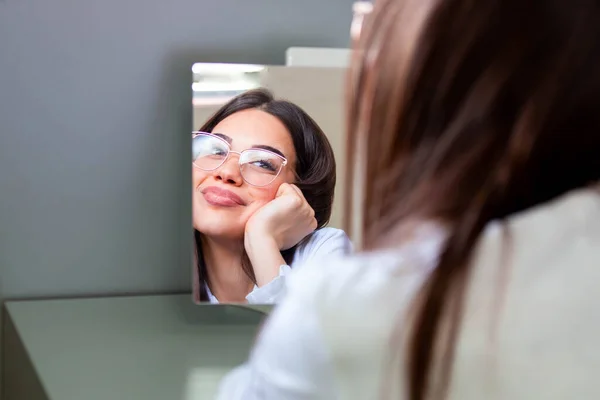 鏡の前で眼鏡をかけてる若い女の子 視力の向上に役立ち 目の健康を救う — ストック写真