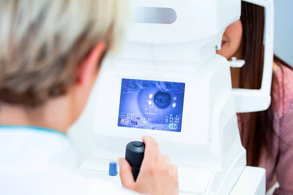 女性医師眼科医は 現代の診療所で魅力的な若い女性の視力をチェックしています 眼科クリニックの医師と患者 — ストック写真