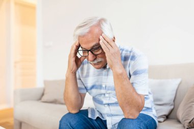 Attack of the monster migraine. Unhappy Retired Senior man holding his head with pain expression . Face of senior man suffering from headache