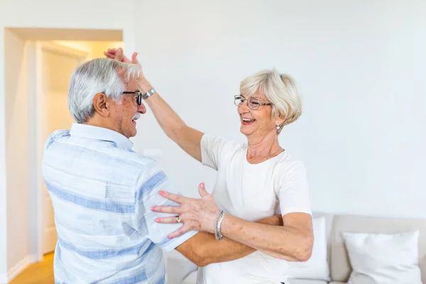 Love lives forever Senior couple at home. Handsome old man and attractive old woman are enjoying spending time together while dancing.