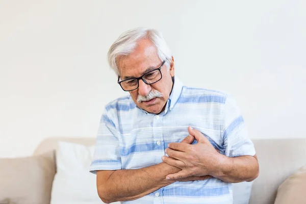 Senior man suffering chest pain, heart attack, problems with breathing, asthma. Elderly man having problems with angina pectoris