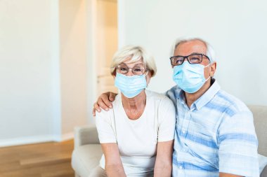 Senior couple wearing medical face mask recovery from the illness at the home. Senior couple with protective mask in quarantine at home during coronavirus covid-19 pandemic