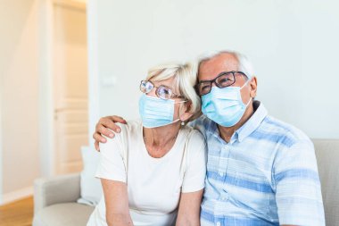 Senior couple wearing medical face mask recovery from the illness at the home. Senior couple with protective mask in quarantine at home during coronavirus covid-19 pandemic