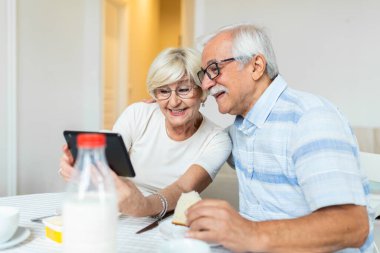 Elderly retired couple talking with their son,daughter and grandchildren via video call. Elderly couple feeling happy. Concept maintaining distance contact.