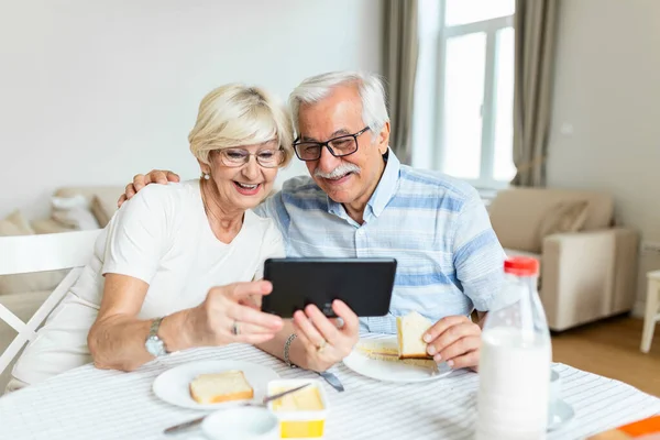 Elderly retired couple talking with their son,daughter and grandchildren via video call. Elderly couple feeling happy. Concept maintaining distance contact.