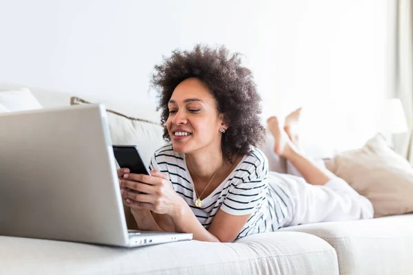Happy Young Black Woman Using Mobile Phone While Sitting Couch — Stock fotografie